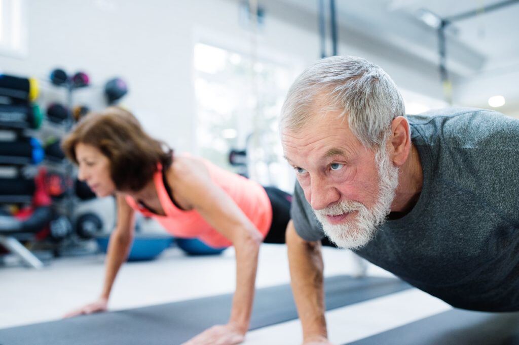 graphicstock-beautiful-fit-senior-couple-in-gym-working-out-doing-push-ups_S_fyZzY8G-min-1024x682